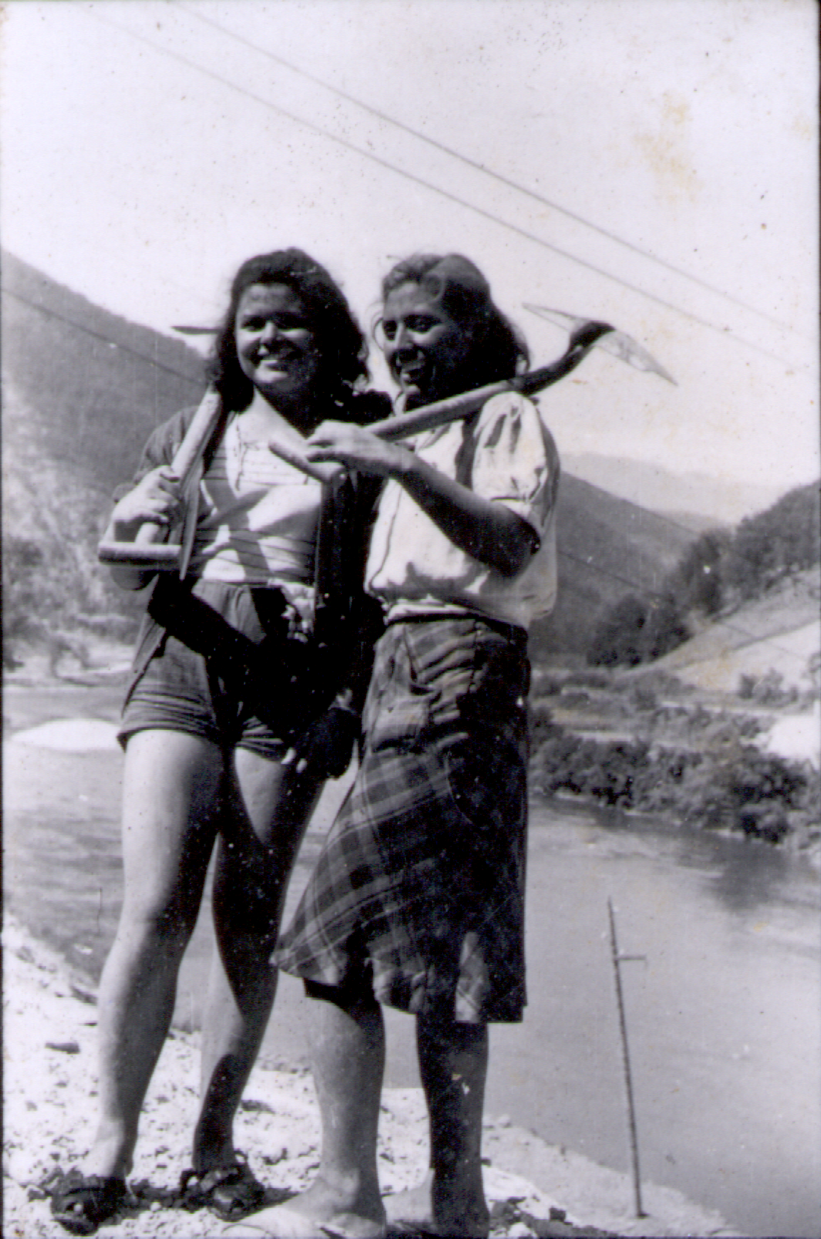 Two young women, holding shovels, at the work action.